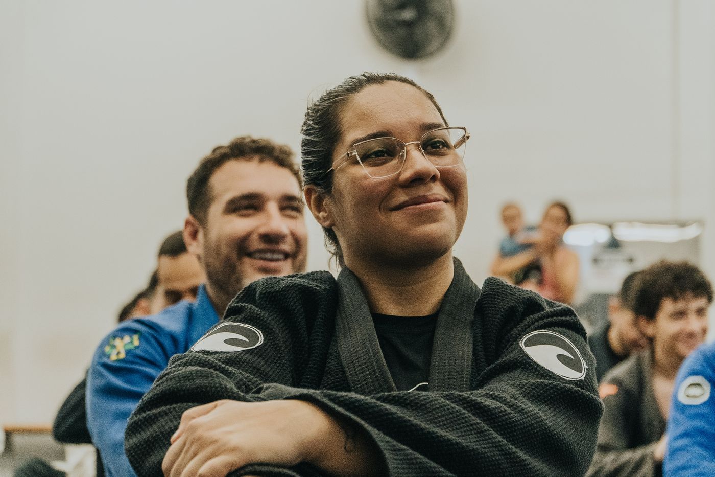 Professora Isa sorrindo ao lado de aluno durante evento na Flow Artes Marciais
